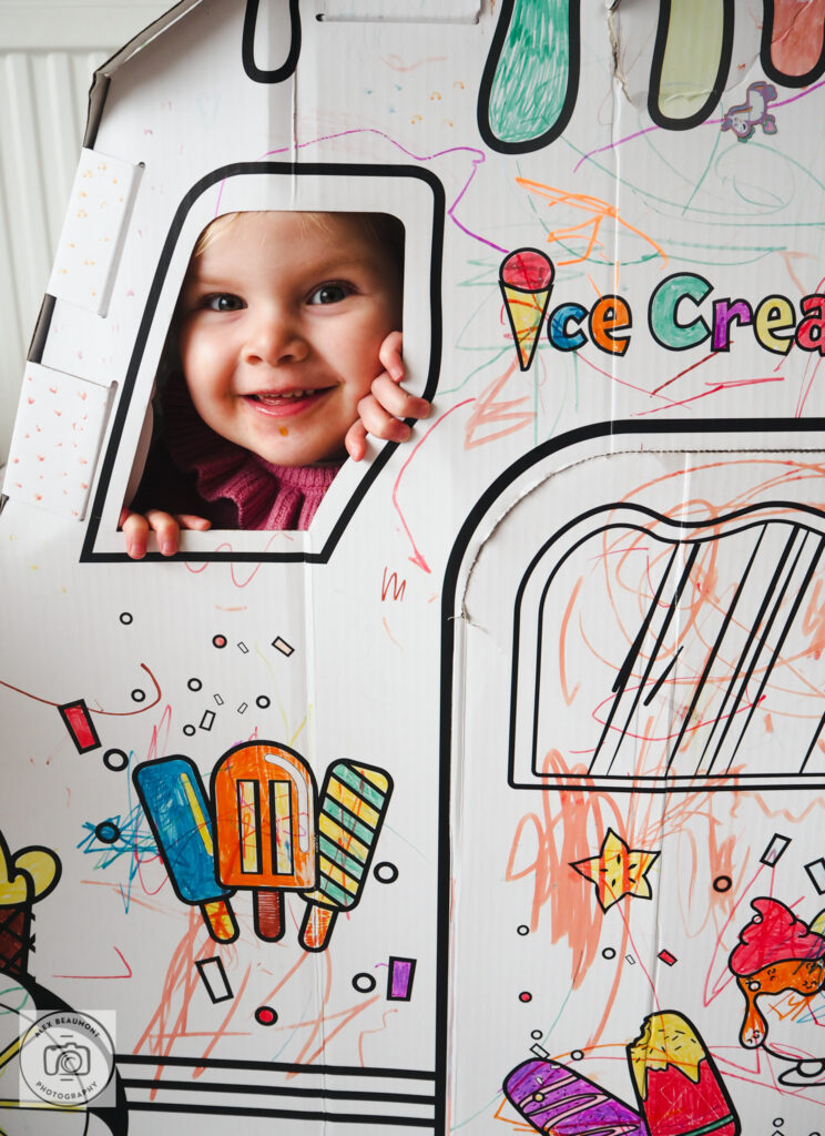 Toddler hiding in colouring play truck