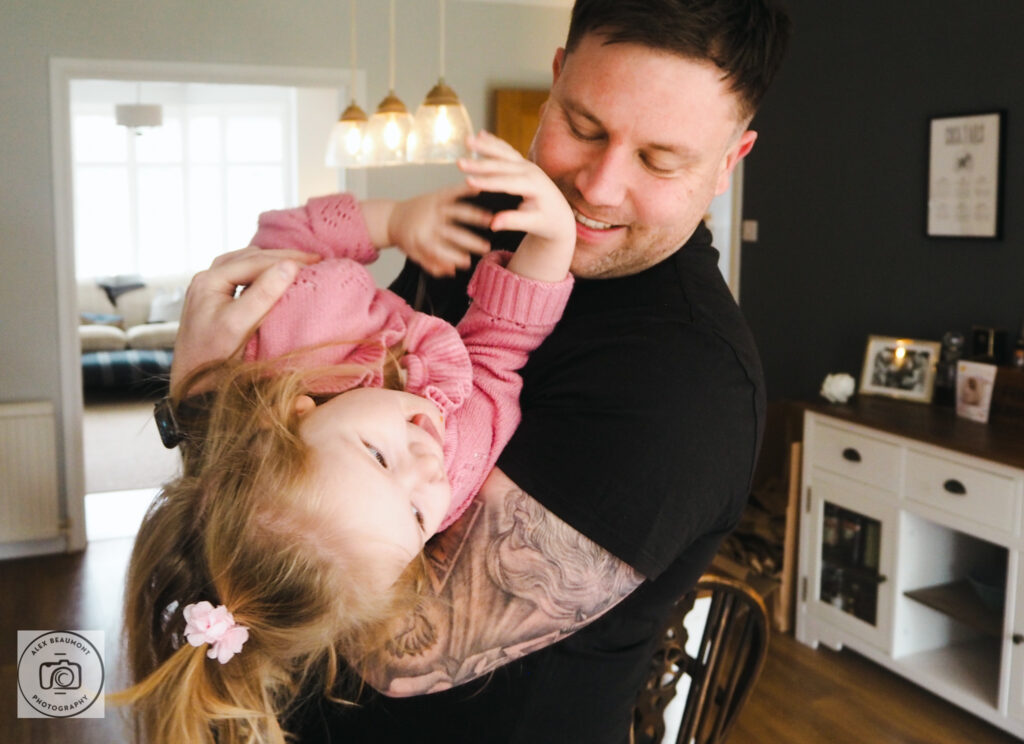 Dad tickling toddler daughter