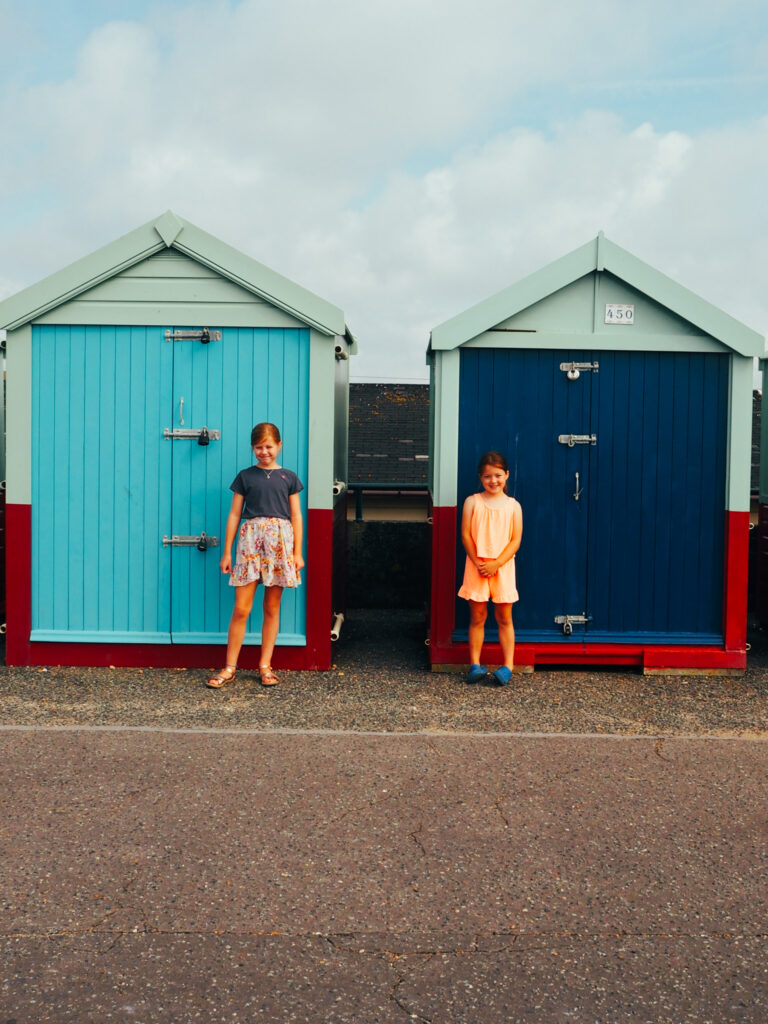 Sisters standing by beach huts