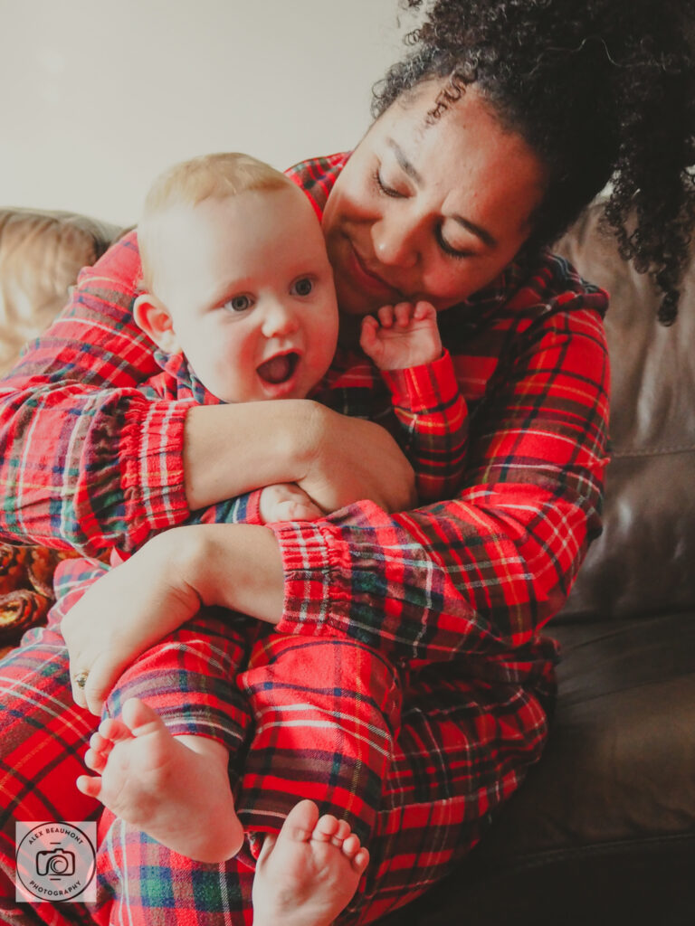 Mum holding baby whilst wearing Christmas pyjamas